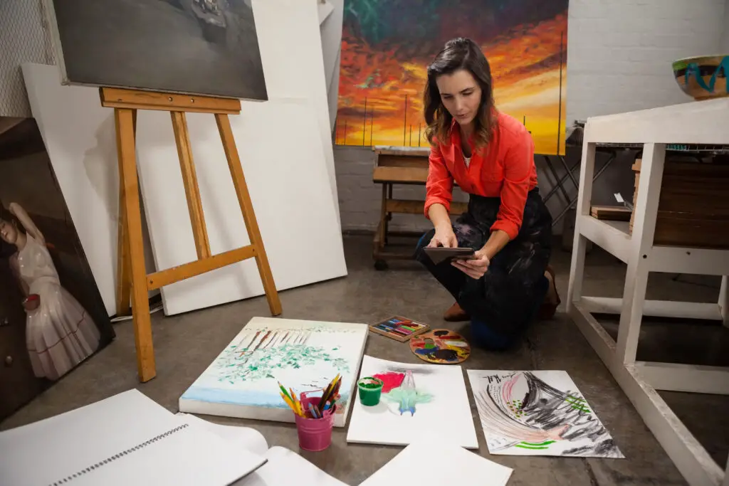 Artist uploading images of hand painted art into AI generator to create new art pieces.
