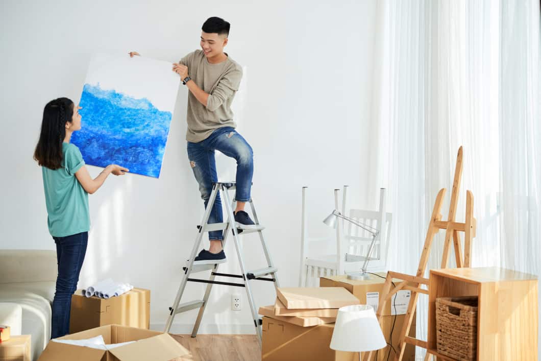Couple hanging canvas art talking questioning can humidity damage paintings