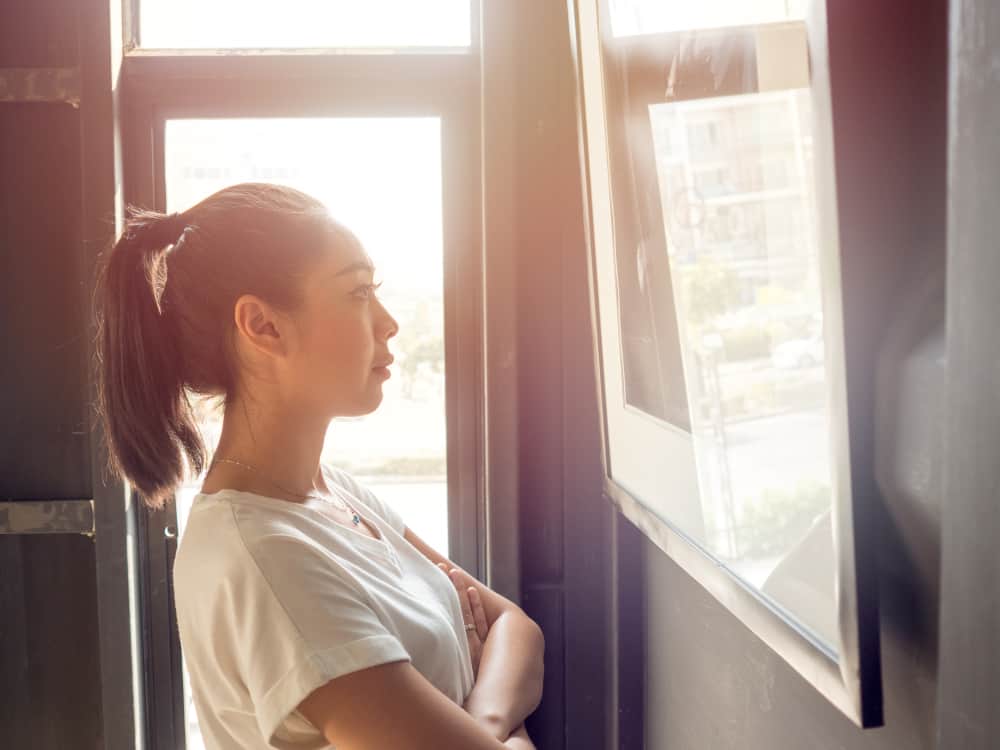 Woman admiring framed picture thinking if humidity can damage fine art photography