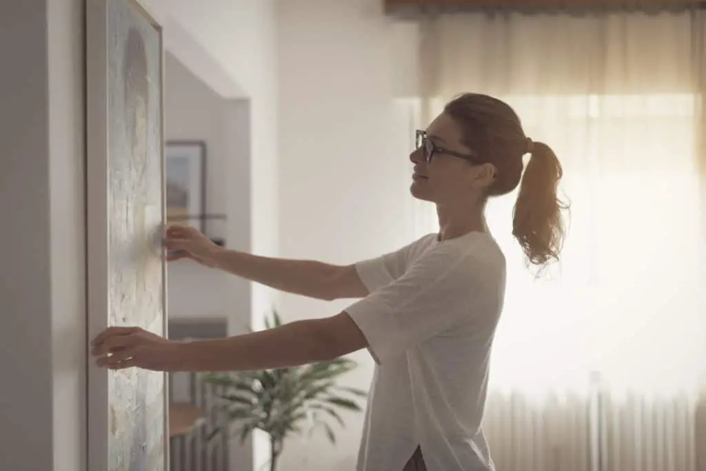 Woman deciding how to display paintings at home