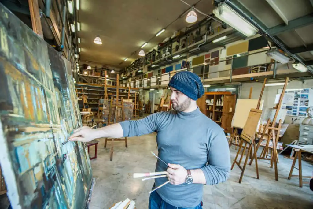 Painter creating a painting during an open studio event where collectors can find local artists