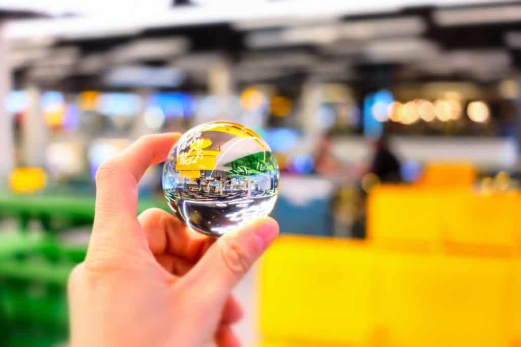 Hand holding glass ball flips the image to show how changing your perspective can help you appreciate art.