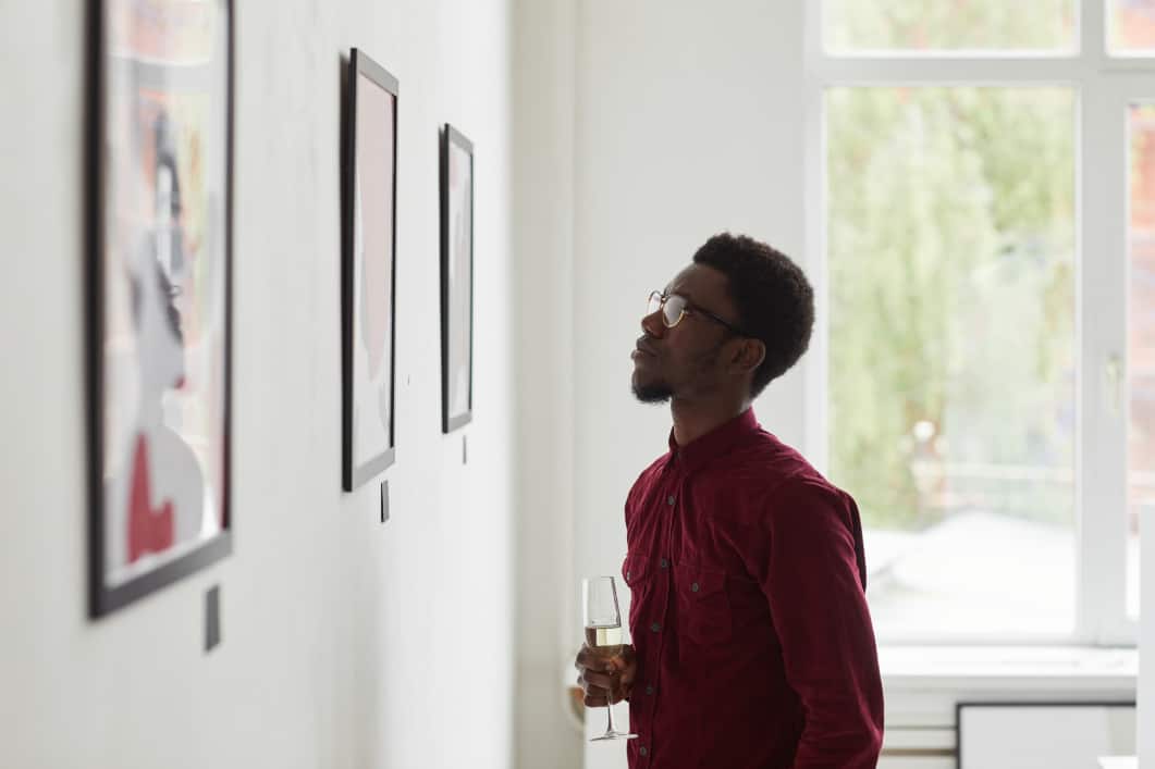 Man staring at illustrations in a gallery after learning what is art appreciation