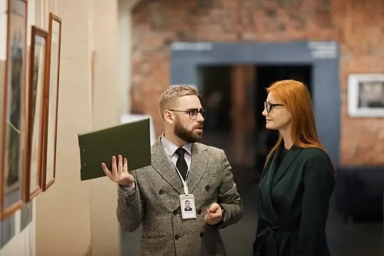 Man in gallery explaining how much an art piece costs.