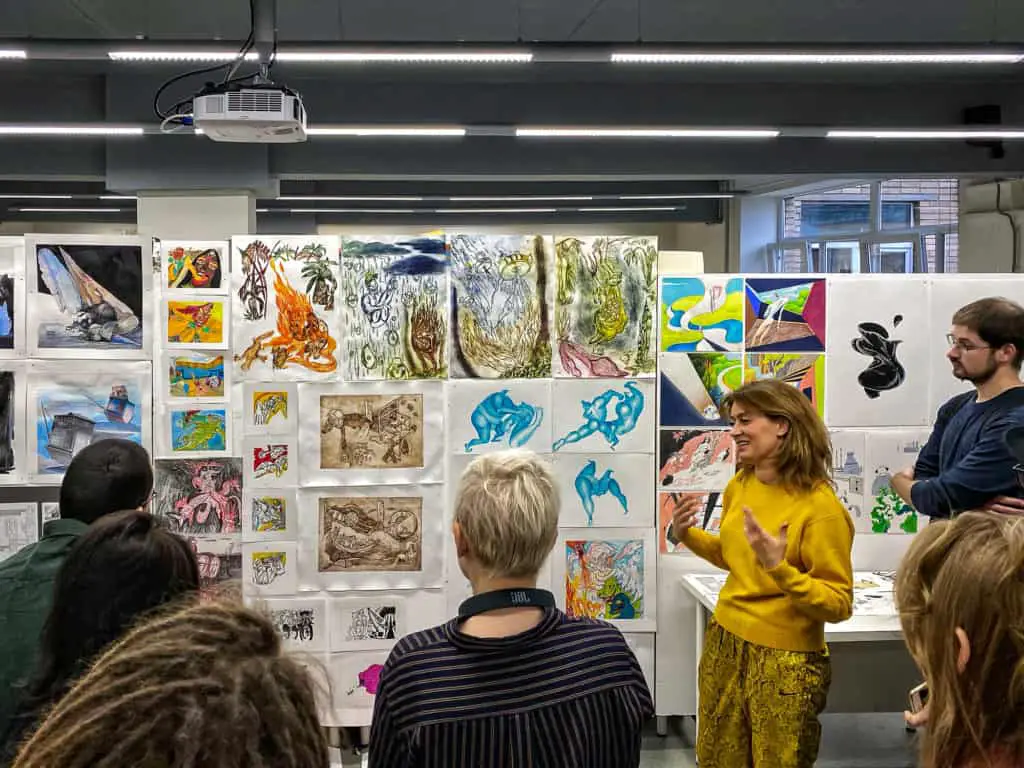 People viewing art at an arts degree show for emerging artists.