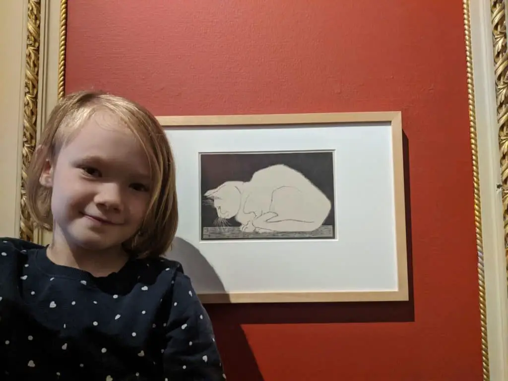 Girl beside sketch of cat she has identified her art style.