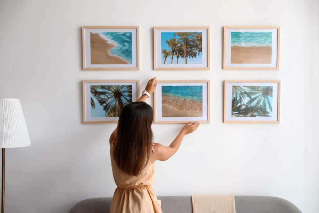 Woman hanging beach prints as she identifies her art style.