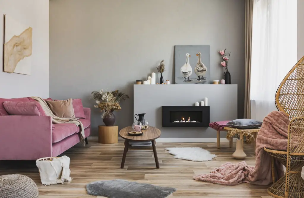 Stylish living room with painting leaned against wall atop fireplace mantle