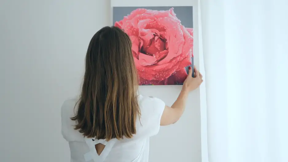 Woman holding picture wondering how to hang wall art without nails