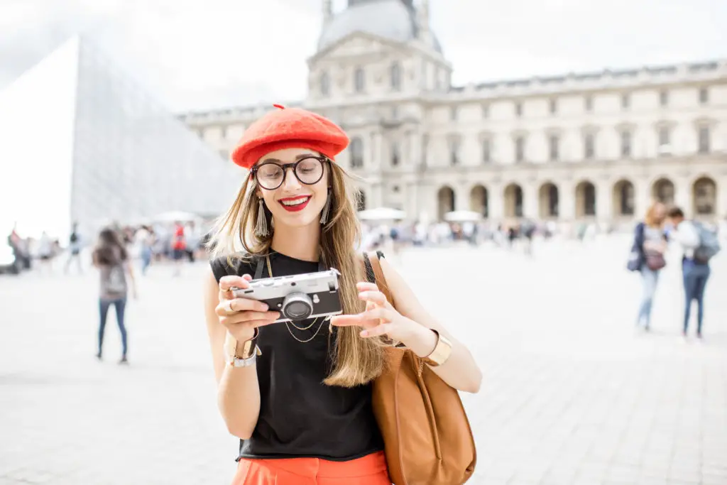 Woman at The Louvre Museum having just learned how to photograph paintings