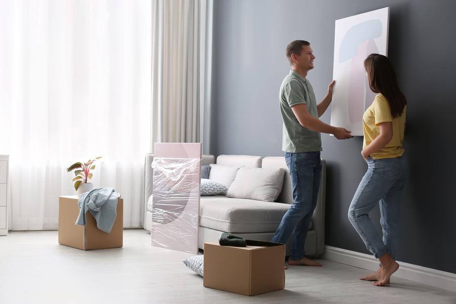 Couple removing wall painting having learned how to store artwork