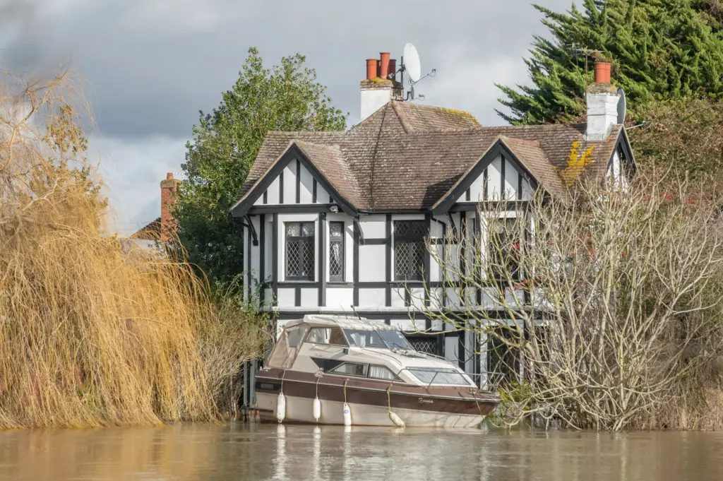 Flooding caused a boat to rise to the second level of tudor-style house.