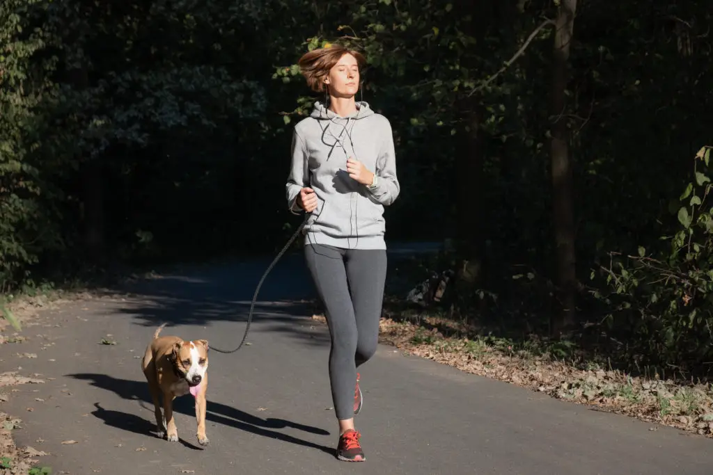 Woman jogging with her dog.