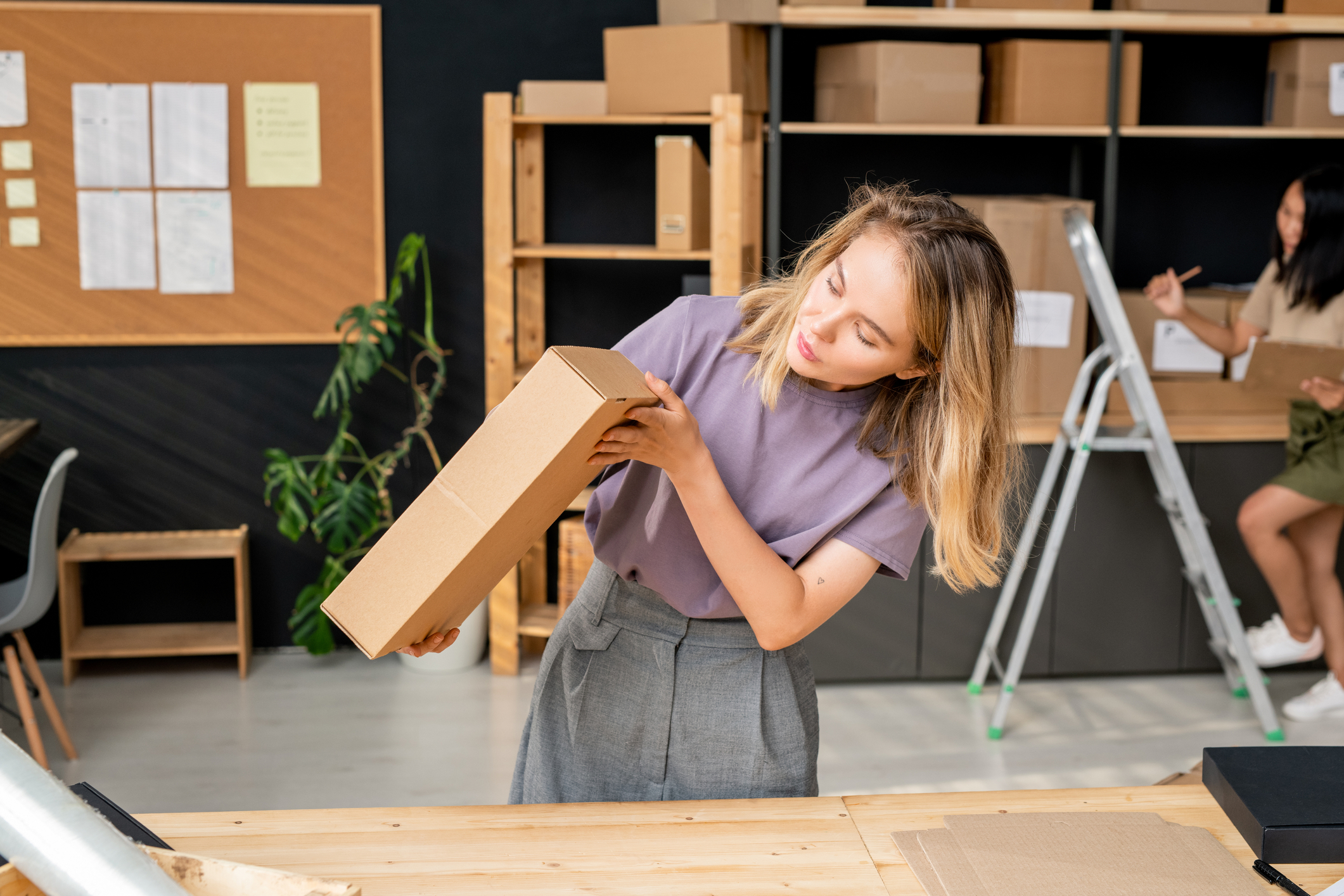 Woman inspecting a box having learned how to ship art
