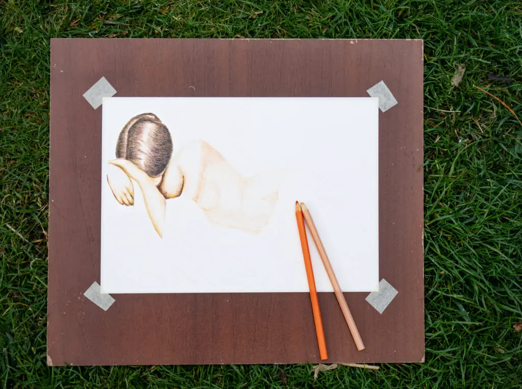 Artist's sketch of a woman on paper that has been carefully affixed at the corners to a board.