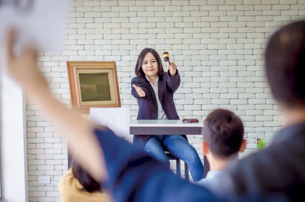 Asian female auctioneer conducting an art auction