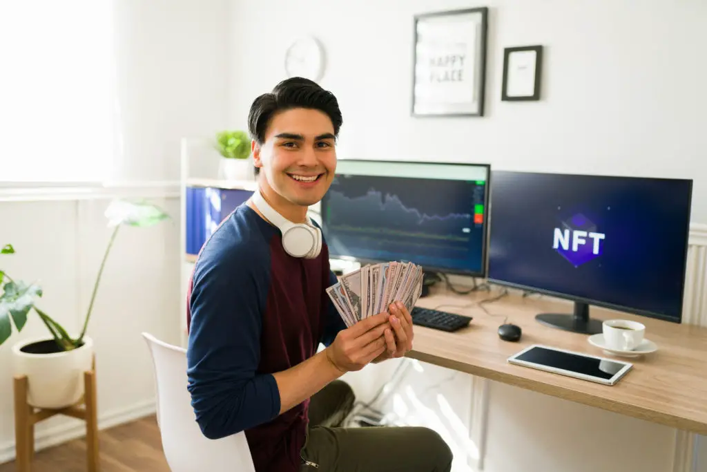 Asian man with headphones holding cash in front of stock market standings and NFTs.
