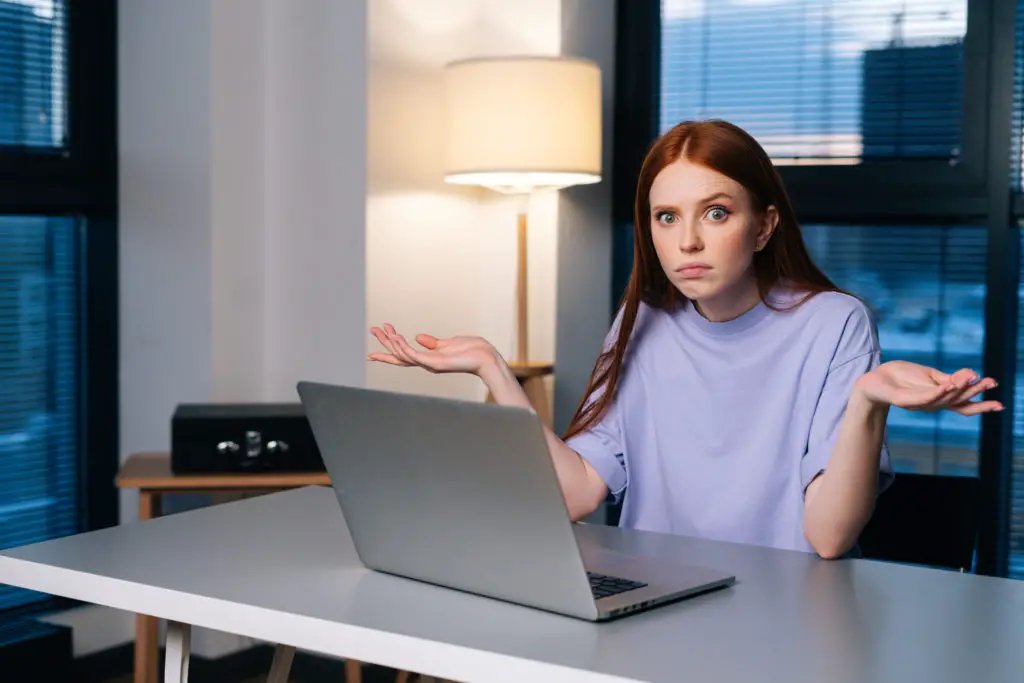 Confused woman using her laptop while trying to buy an NFT.