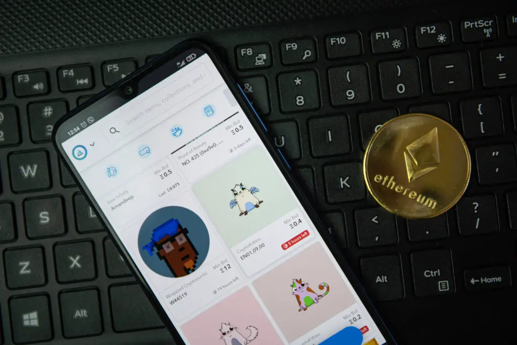 A phone signed into OpenSea marketplace on a keyboard with an Ethereum coin.