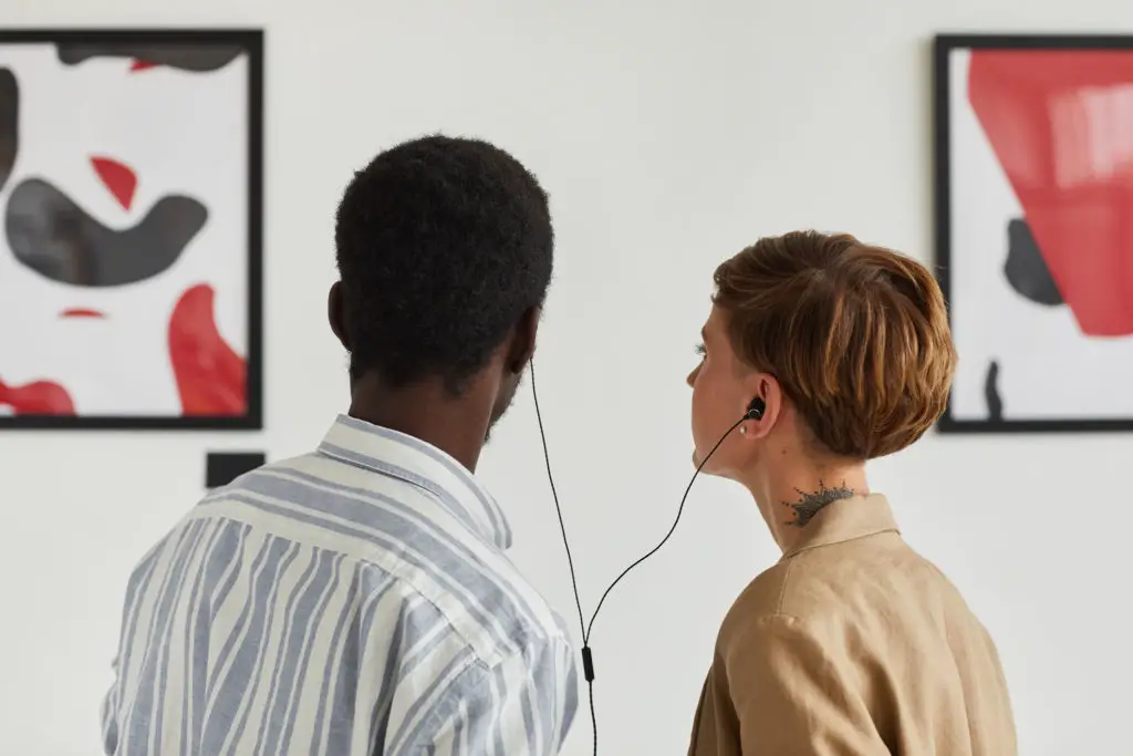 Couple in art gallery listening to audio guide.