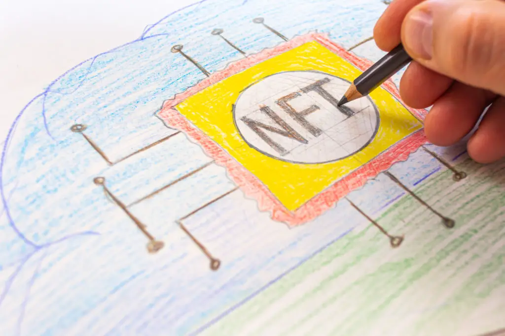 A hand drawing the concept of NFTs.