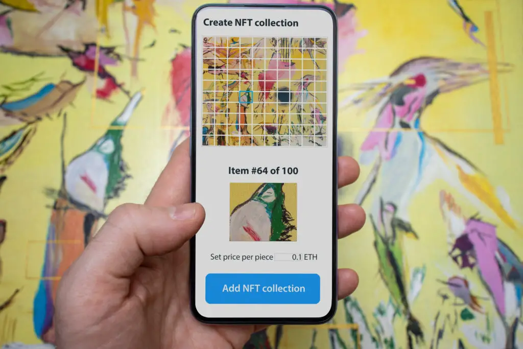 A person using their phone to take a picture of a physical art painting to turn it into an NFT.